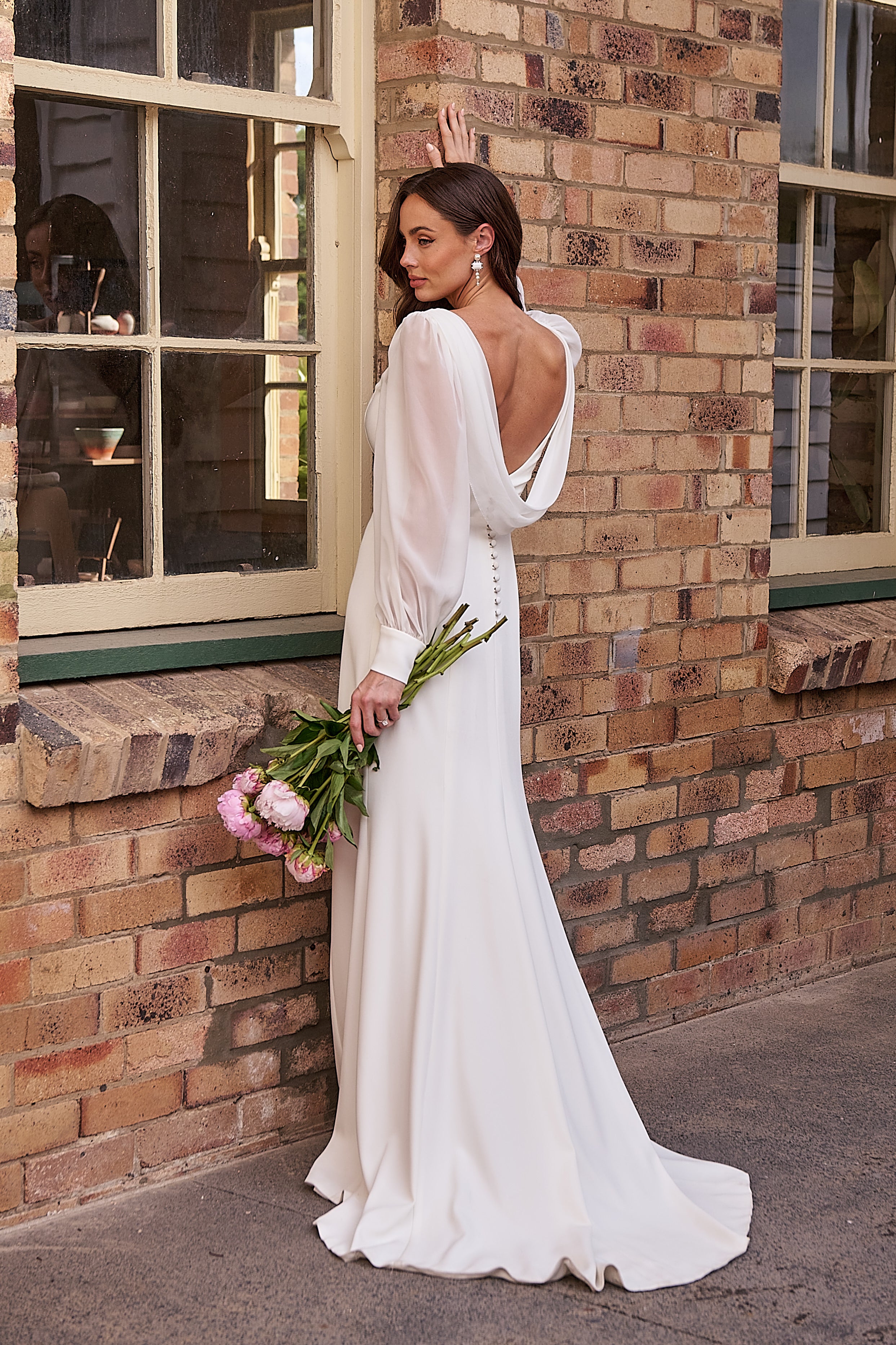 Back of crepe wedding gown with plunging cowl back, structured bodice, button detail and flowing georgette bishop sleeves.