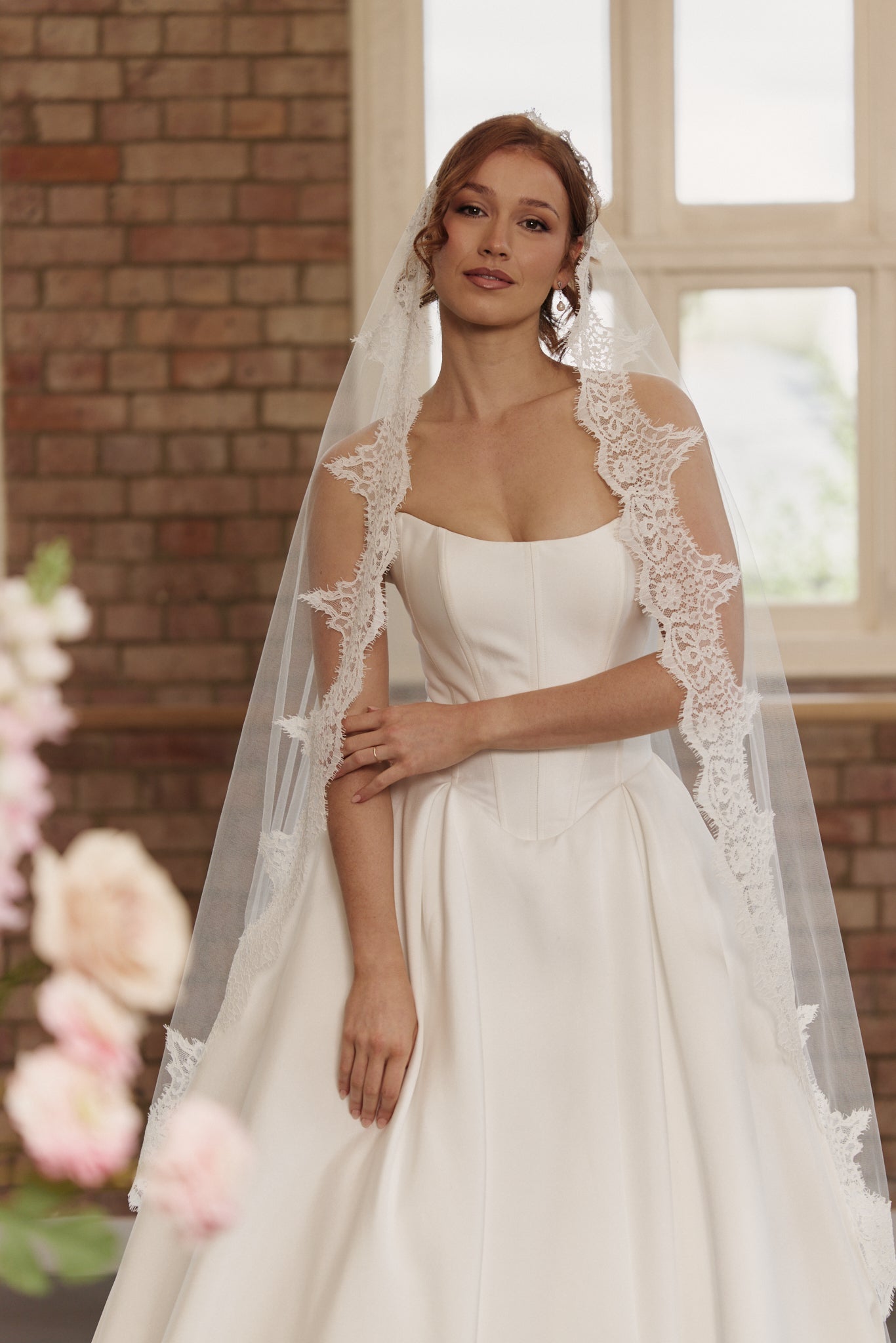 Front view of the Mackenzie wedding dress featuring a strapless corset bodice, scoop neckline, and full princess ball gown skirt.