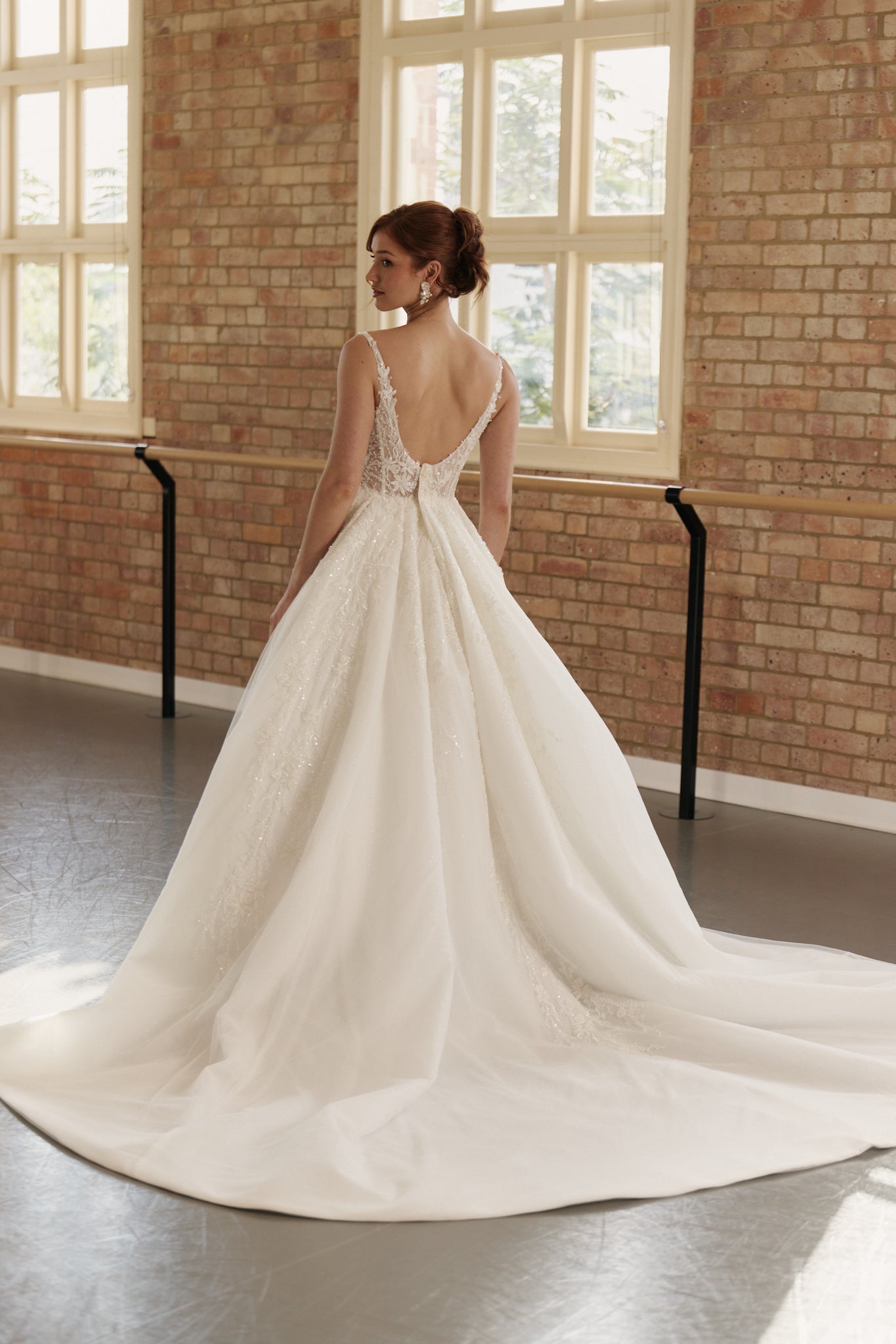 Back view of the Ophelia wedding dress showcasing basque waist, layered organza skirt, and intricate lace detailing.
