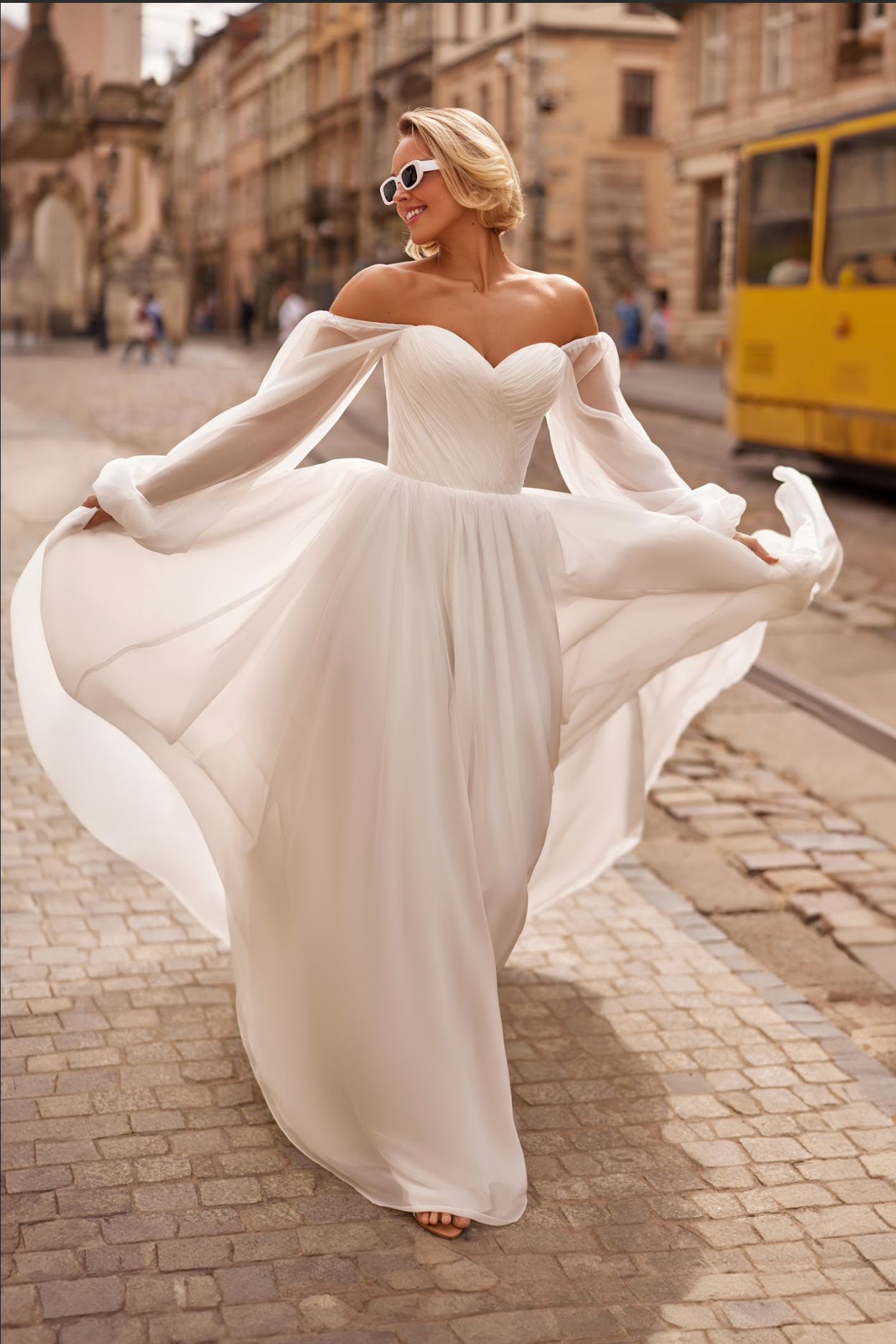 Petra Wedding Gown, Corset bodice, a line silhouette, draped ing light chiffon fabric, strapless with billowy chiffon sleeves.