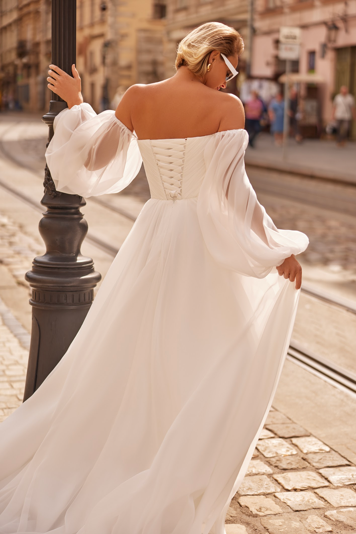 Petra Wedding Gown, Corset bodice, a line silhouette, draped ing light chiffon fabric, strapless with billowy chiffon sleeves.