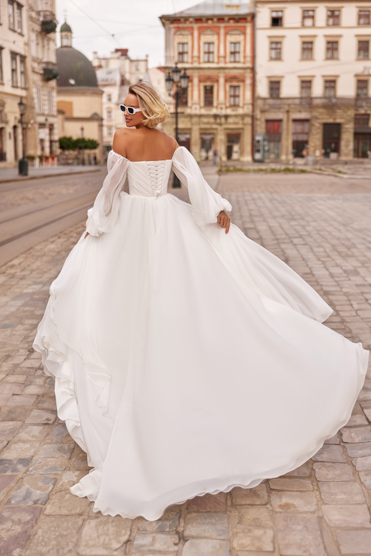 Petra Wedding Gown, Corset bodice, a line silhouette, draped ing light chiffon fabric, strapless with billowy chiffon sleeves.