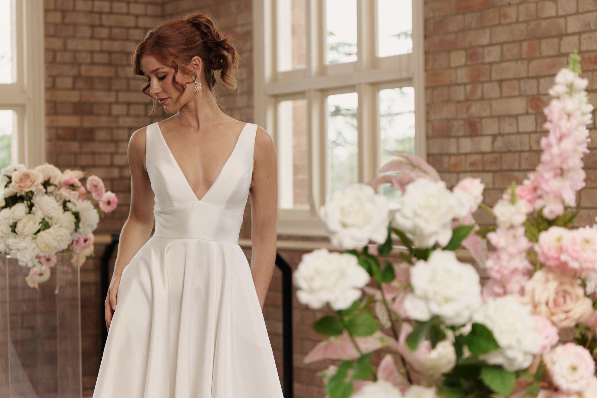 Front view of the Rachel wedding gown in Mikado with deep V-neckline, cinched waistband, and full princess-style skirt.