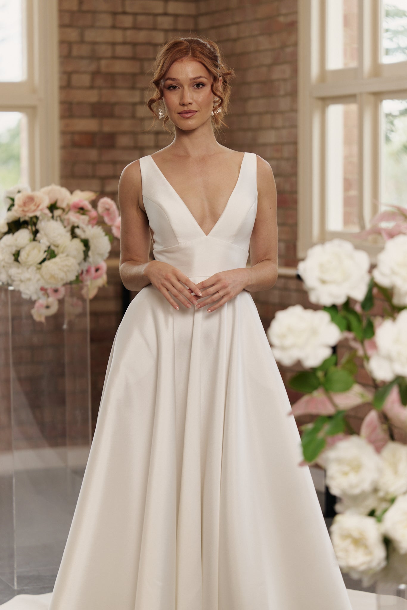 Front view of the Rachel wedding gown in Mikado with V-neckline, cinched waistband, and full princess-style skirt.
