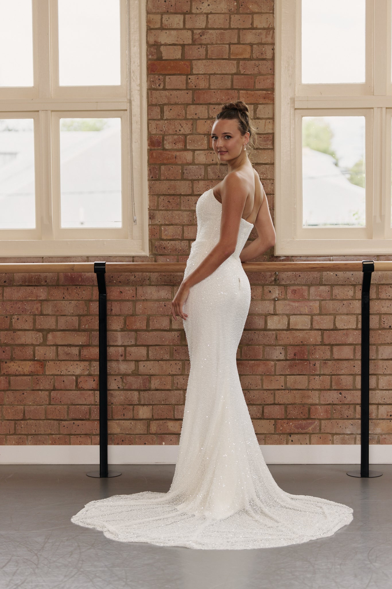 Back view of the Rebecca bridal gown showing subtle V-back and streamlined mermaid silhouette.
