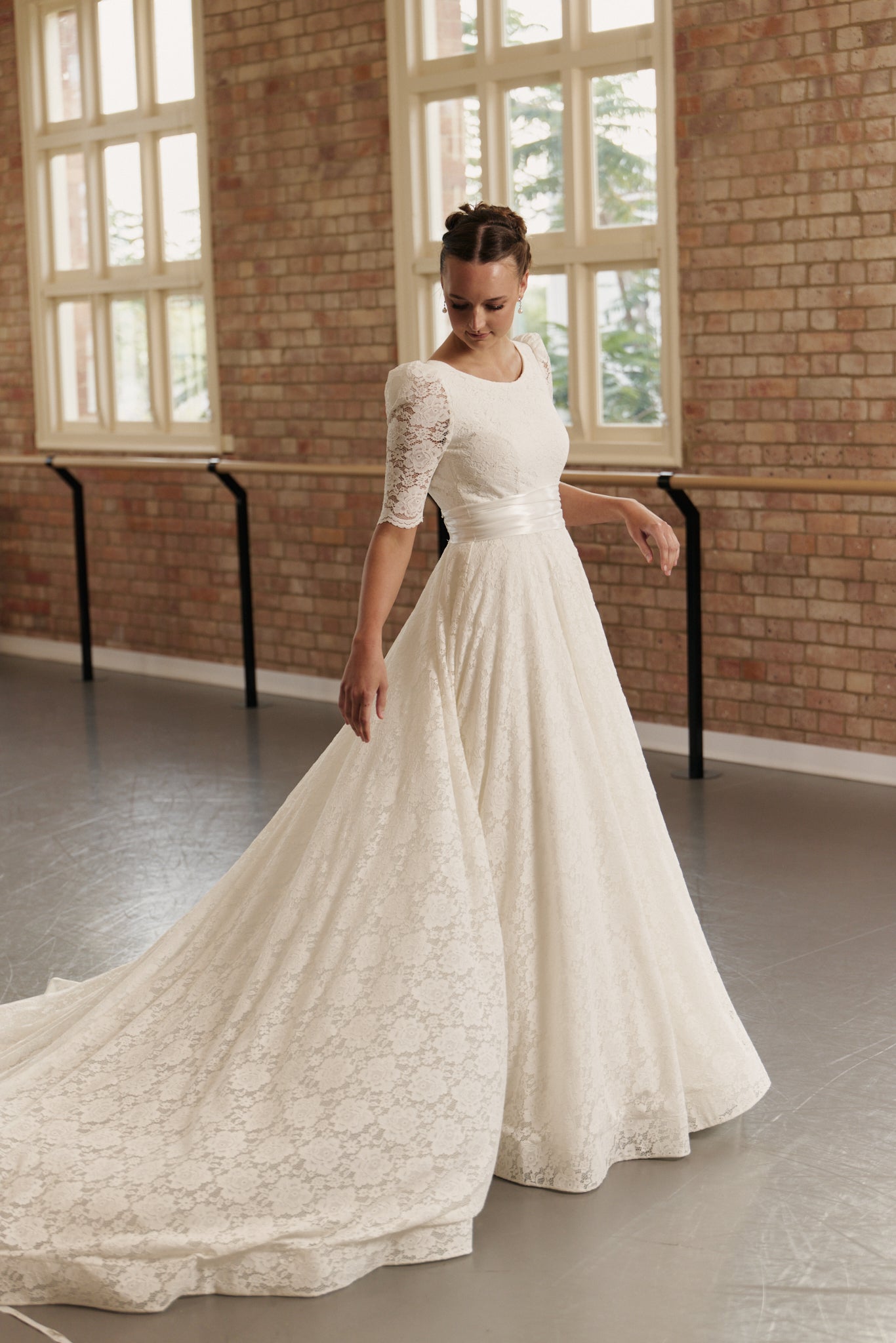 Side profile of the Roma gown highlighting the soft boat neckline, structured ruched waistband, and elegant A-line silhouette.