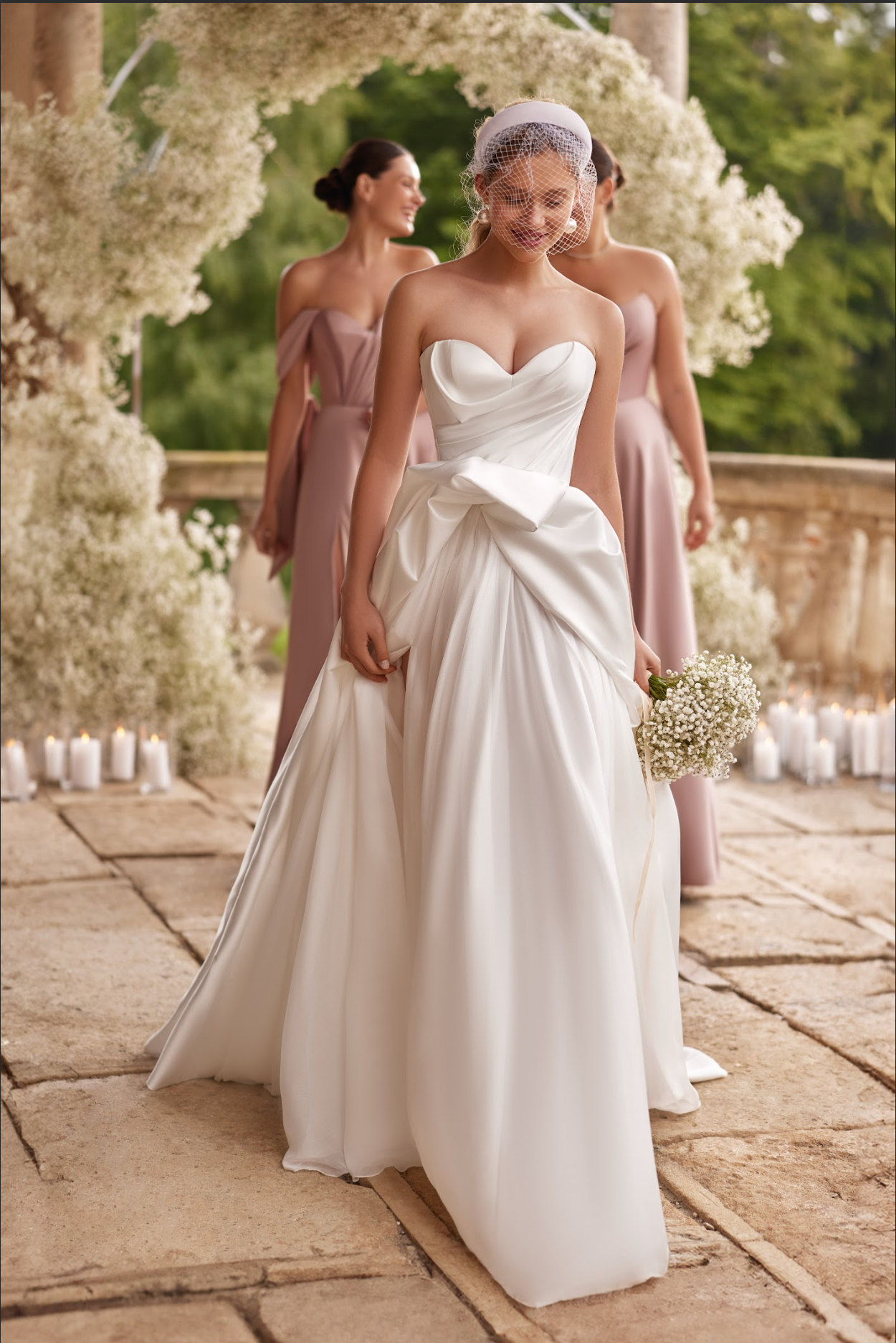 Sofi Wedding Gown, with satin corset, a-line silhouette, long skirt with split and train, ruched bodice, strapless with sweetheart neckline, ruffle detail around skirt top.