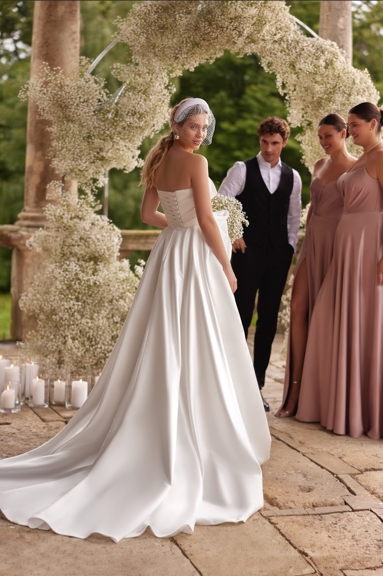 Sofi Wedding Gown, with satin corset, a-line silhouette, long skirt with split and train, ruched bodice, strapless with sweetheart neckline, ruffle detail around skirt top.