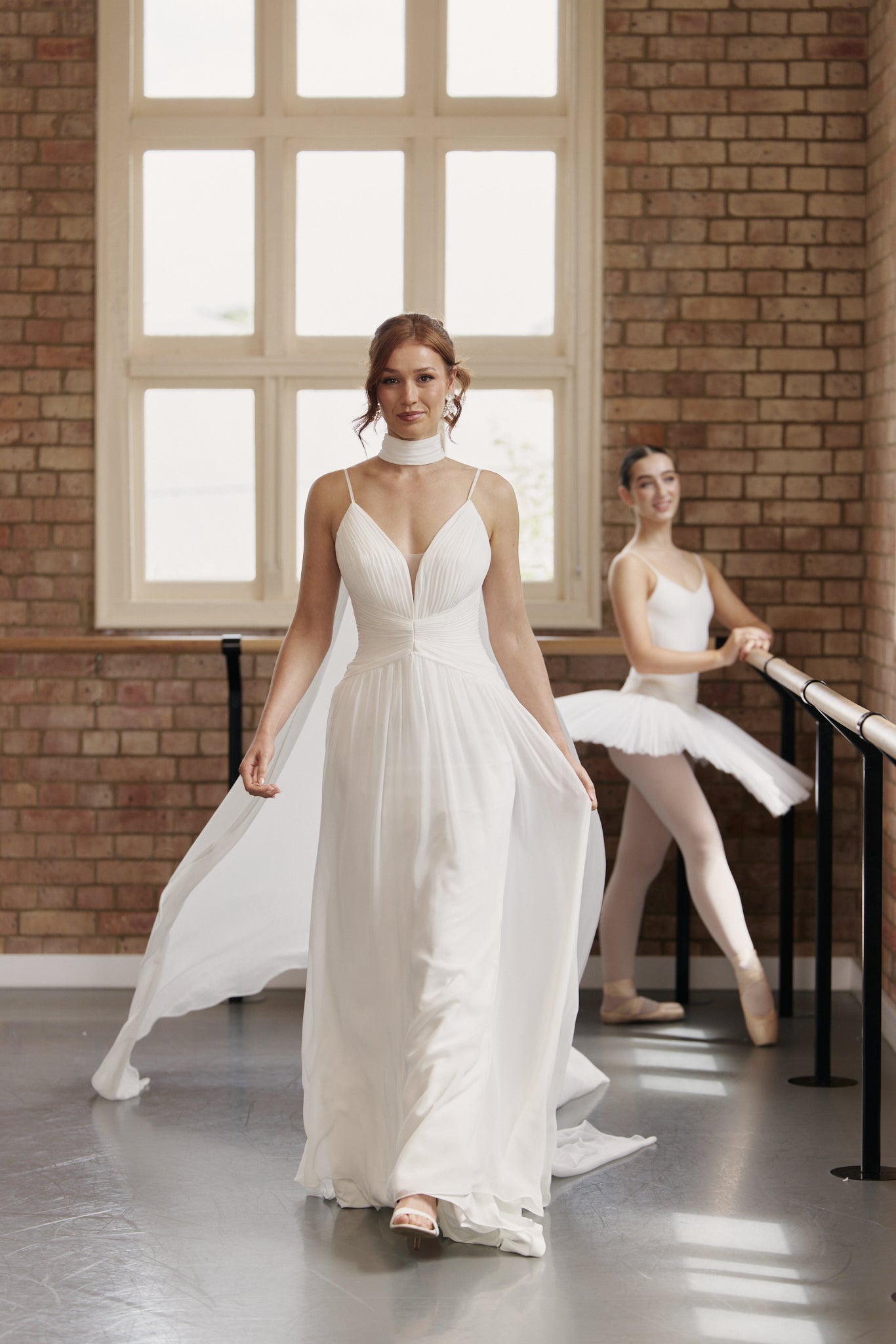 Bride wearing chiffon neck scarf with soft collar and flowing panels instead of a veil.