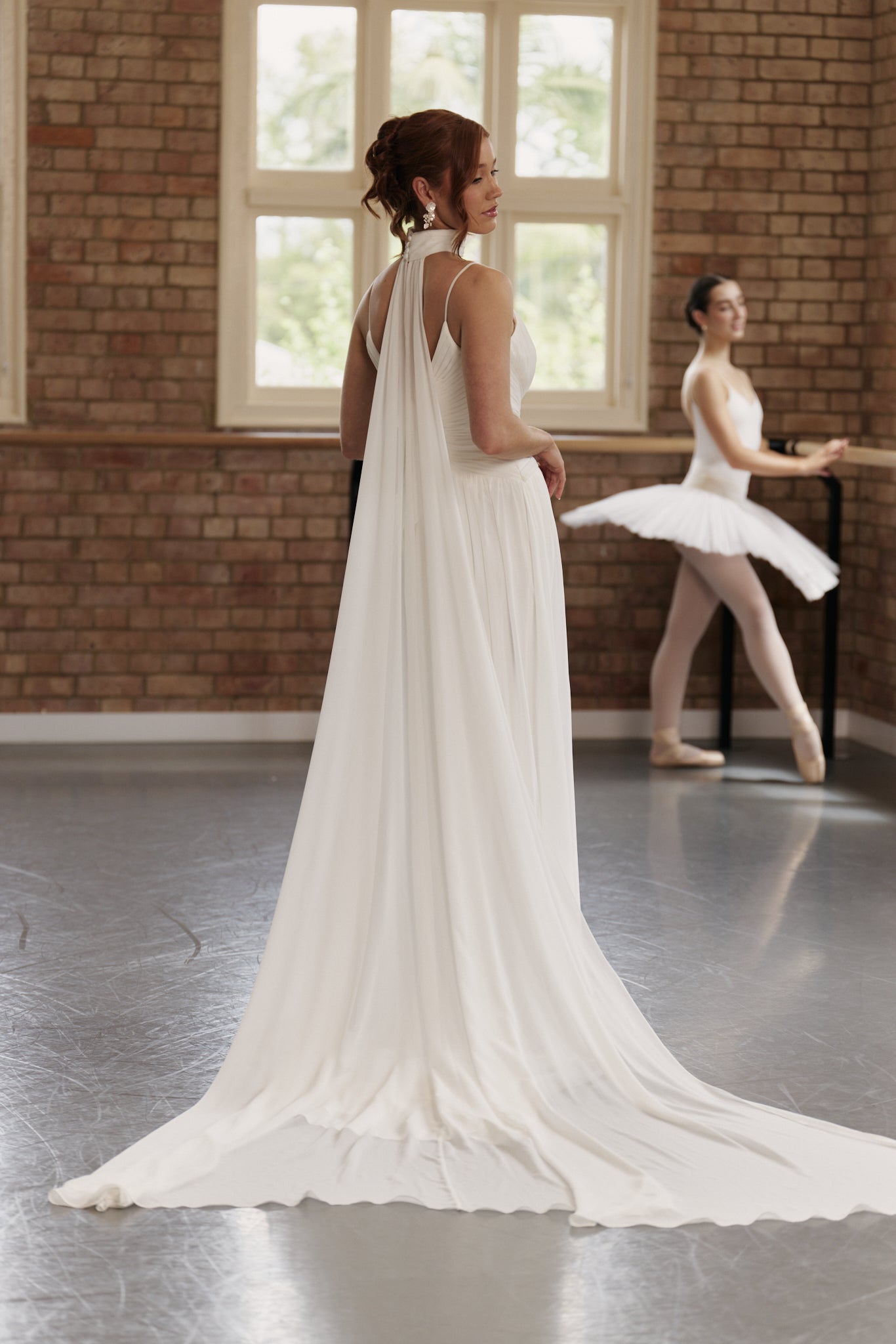 Bride wearing chiffon neck scarf with soft collar and flowing panels instead of a veil.
