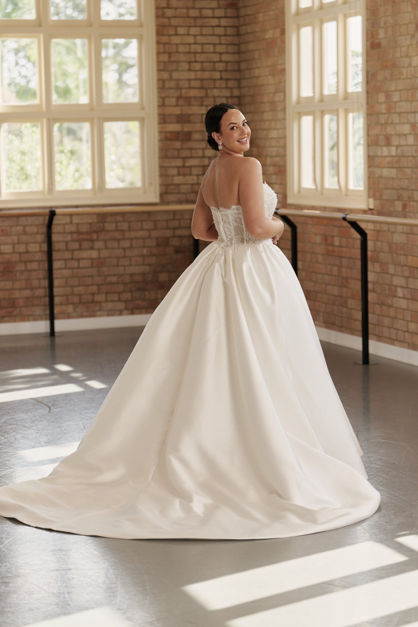 Elegant princess basque waist wedding dress with intricate beaded lace and structured corset for timeless bridal elegance.