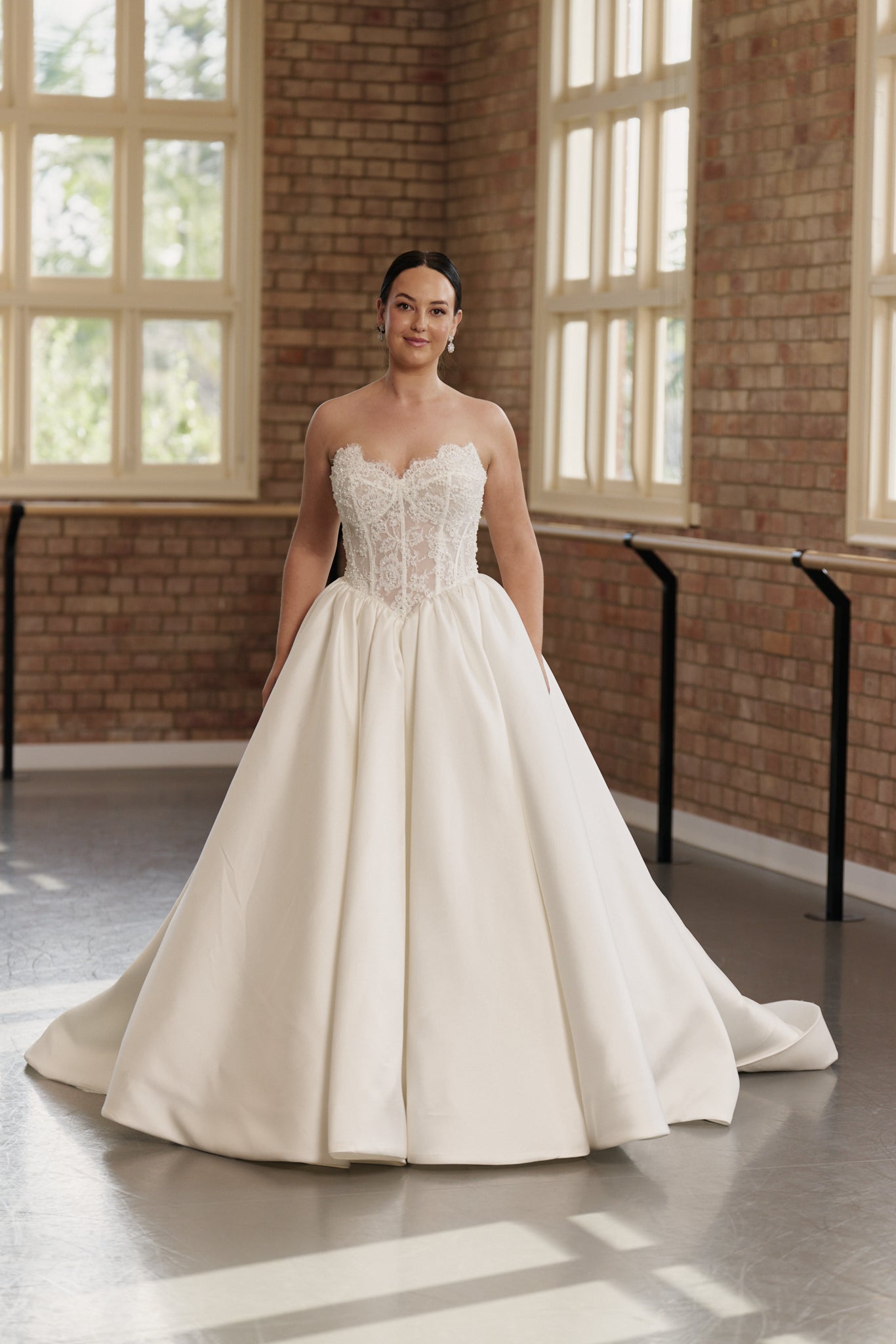 Elegant princess wedding dress with basque waist, intricate beaded lace and structured corset for timeless bridal elegance.