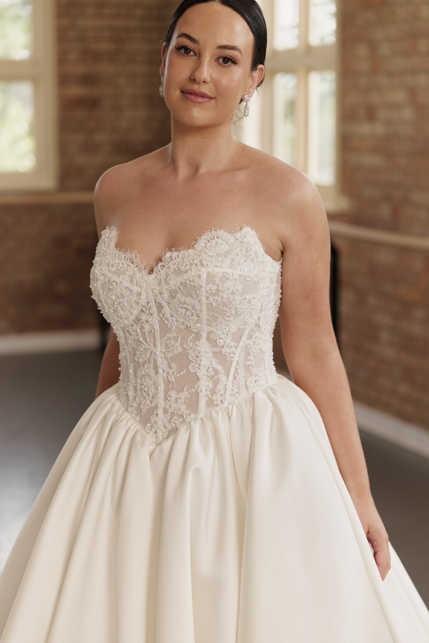 Flattering basque waist ball gown with beaded lace bodice and supportive corset for dancing and celebration.