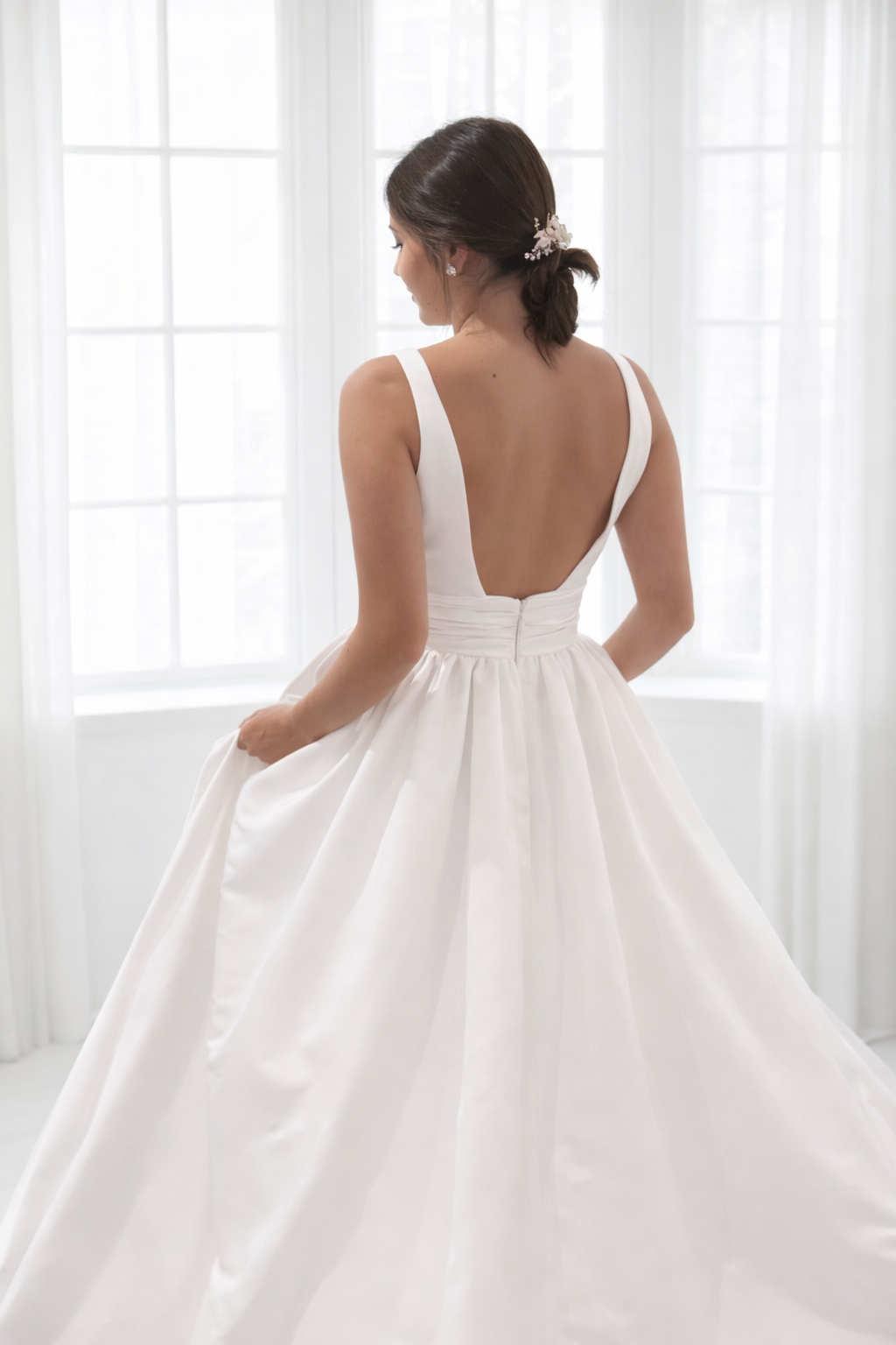 Minimalist Laura wedding gown with classic boat neck and full skirt, back view.